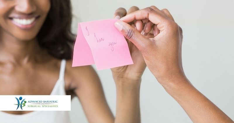 Woman sticks a note on her mirror that says "I love you" as she learns to love herself and her body after weight loss surgery with Dr. Craig Chang