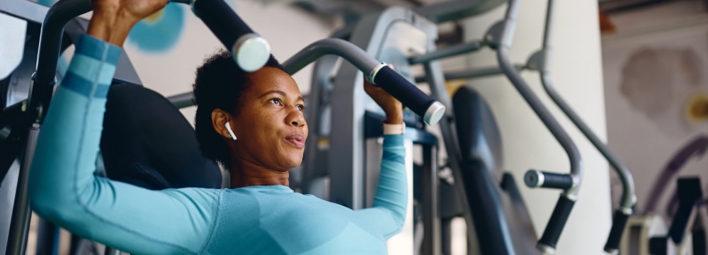 Woman using workout machine in gym, focused 