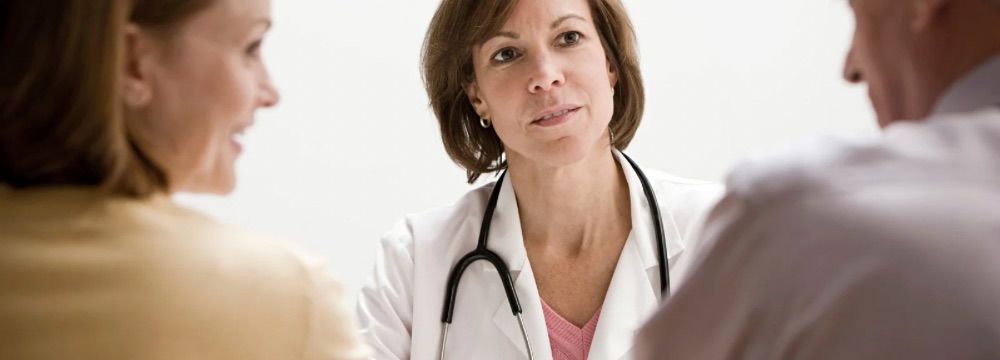 Doctor looking towards woman and man, focused stare