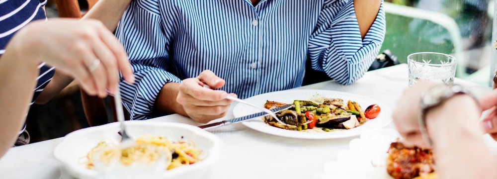Woman playing with food, experiencing appetite loss at restaurant 