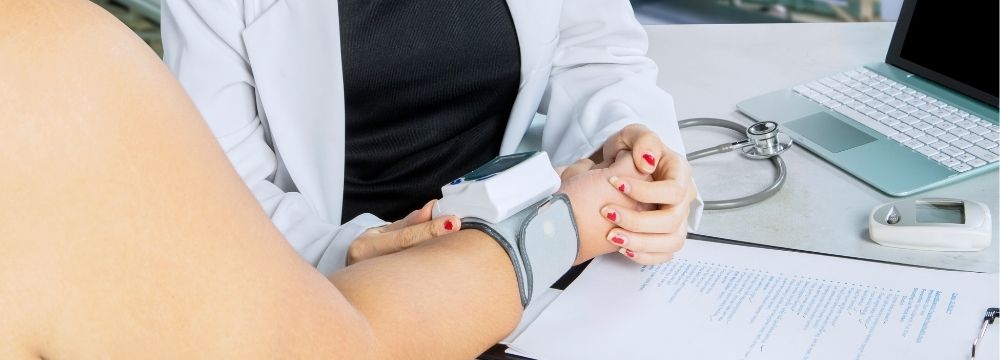 Obese woman having blood pressure taken by doctor