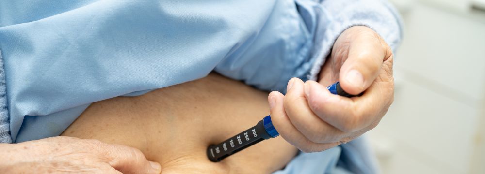 . man taking GLP-1 injection in stomach