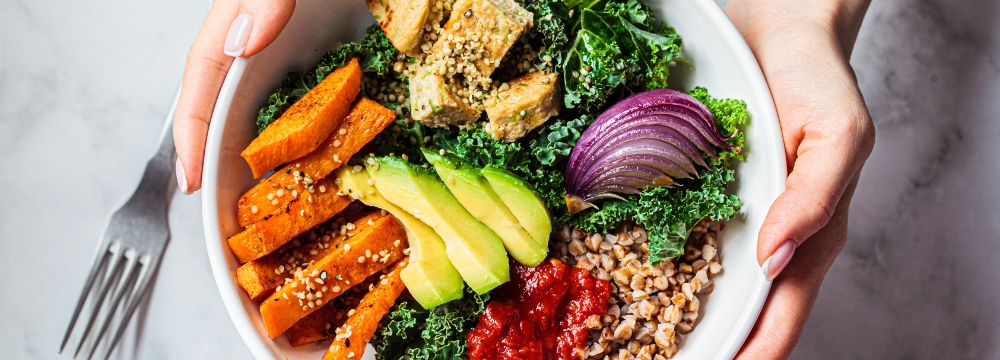 Woman holding bowl of colorful foods